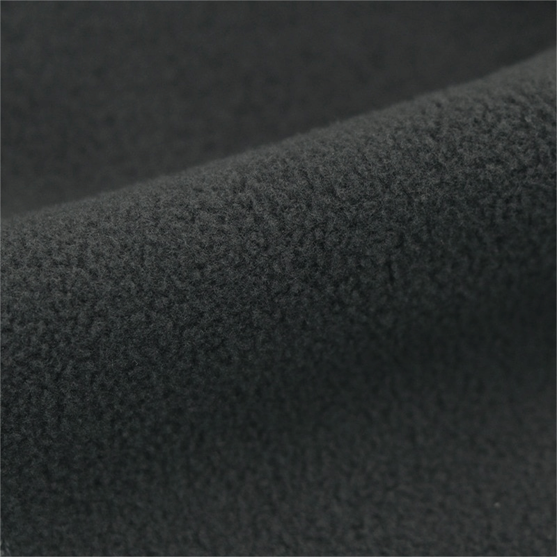 Close-up of black windproof fleece fabric showing texture and warmth.